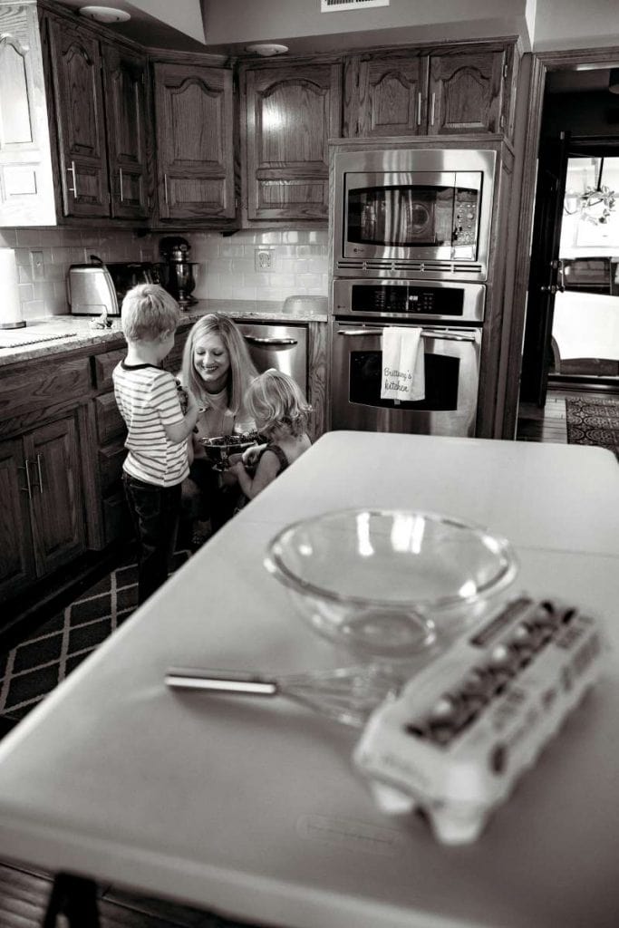 mother serving her two kids a snack in kitchen