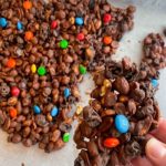 hand breaking off piece of chocolate candy bark