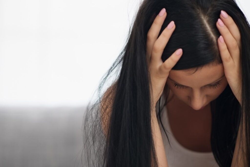 lady with head down and hands over head as if stressed